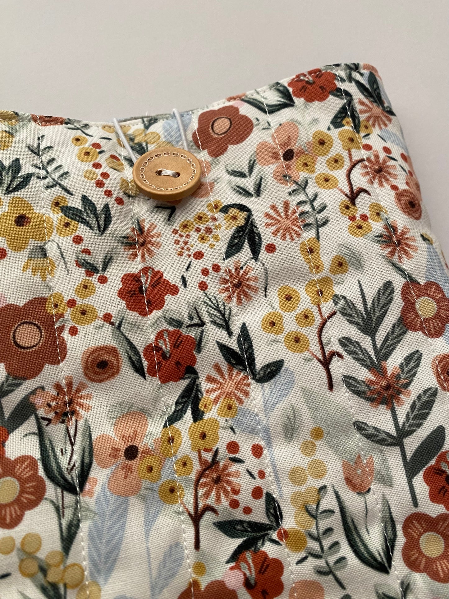 Floral patterned fabric with a button on a white background