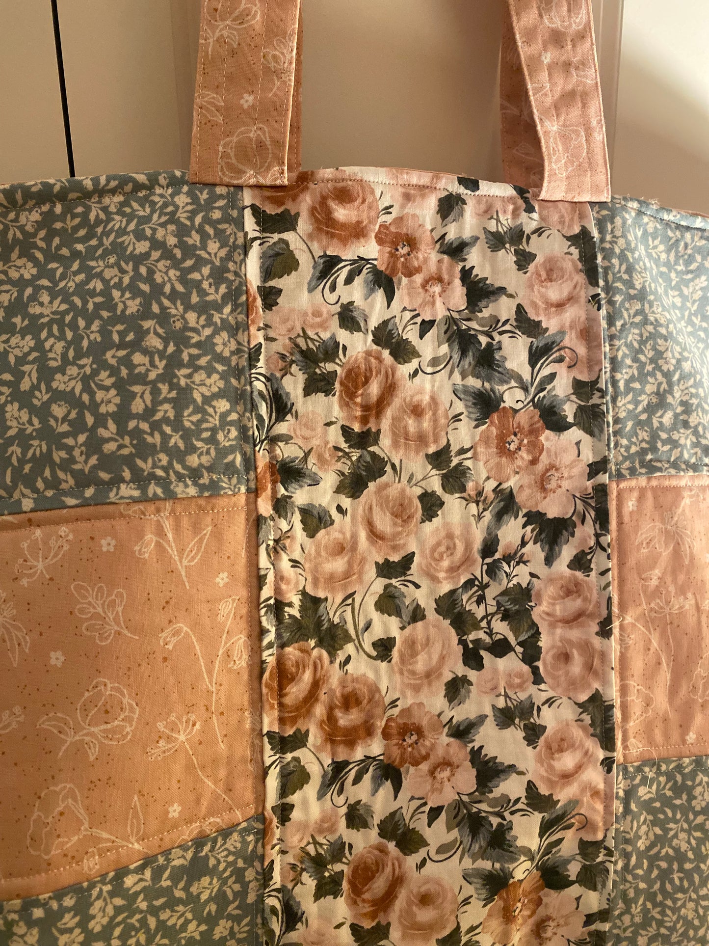Floral patterned fabric with a patchwork design on a neutral background