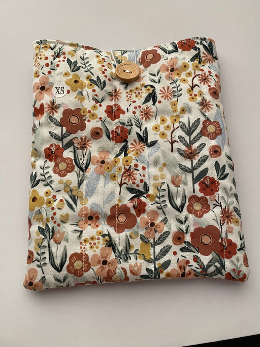 Floral patterned cushion with a button on a white background