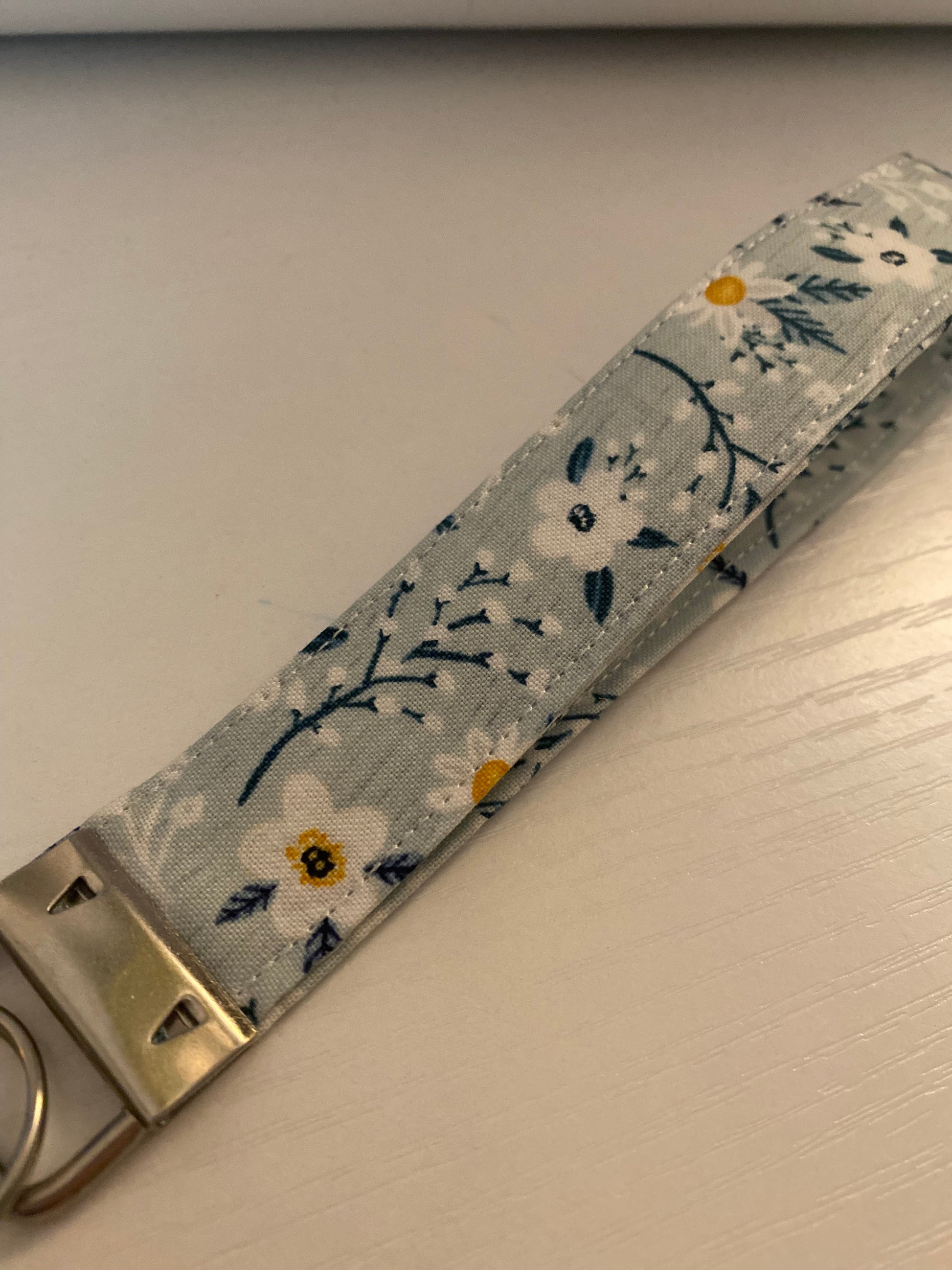 Floral-patterned keychain strap on a neutral background