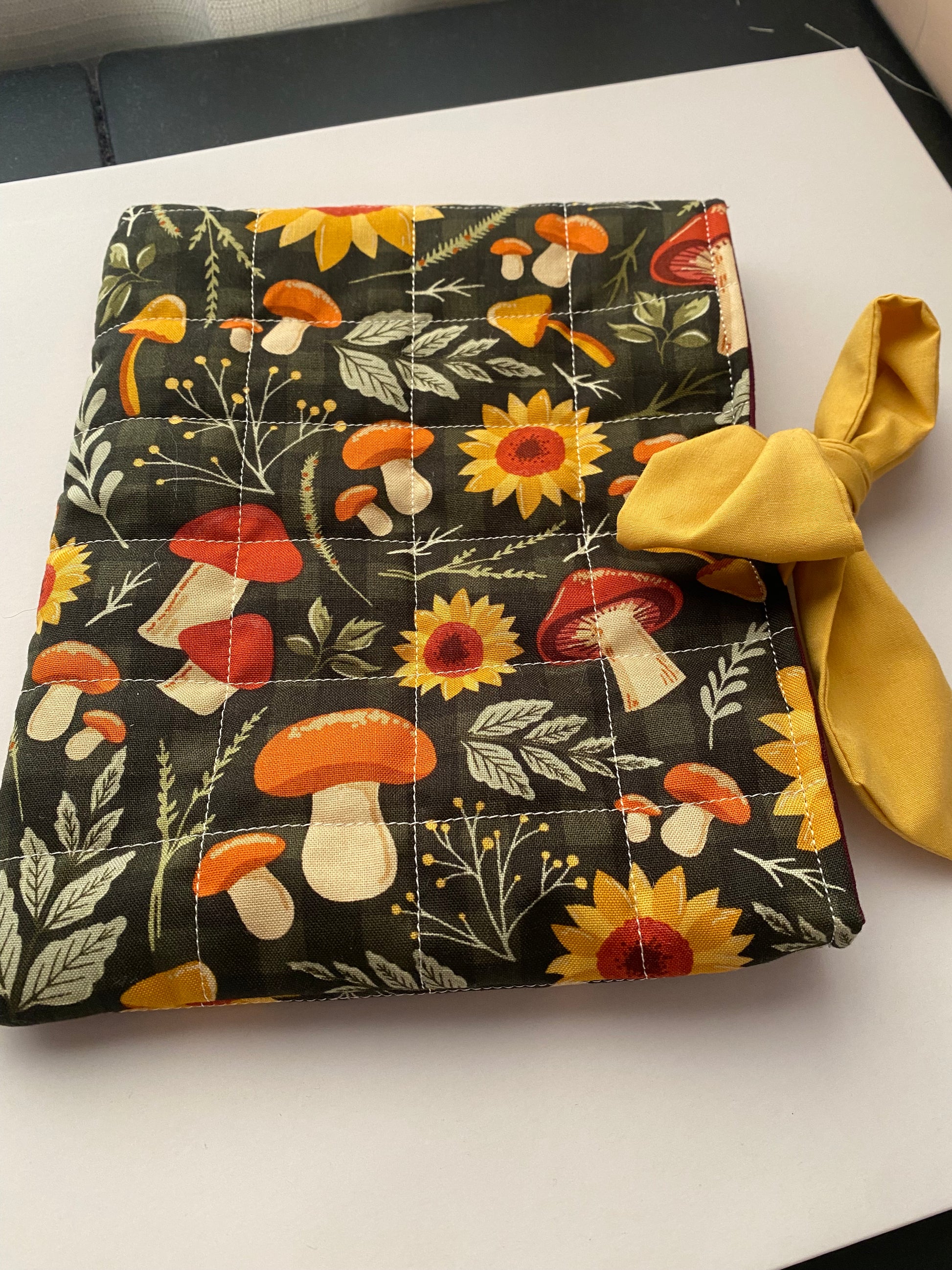 Fabric pouch with floral and mushroom pattern on a white background