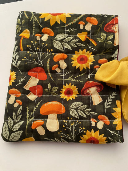 Floral and mushroom patterned pouch with a yellow bow on a white background